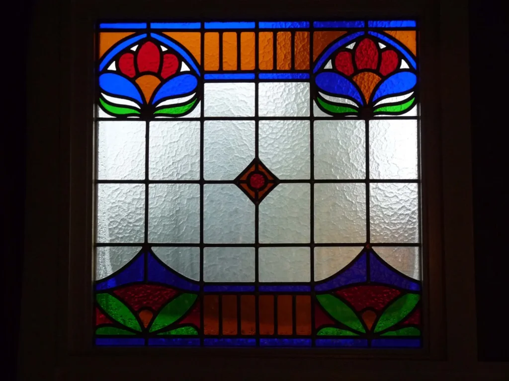 Art-nouveau bloemmotief glas-in-loodraam, uitgevoerd voor Café Sous Les Eglises in Beek-Ubbergen