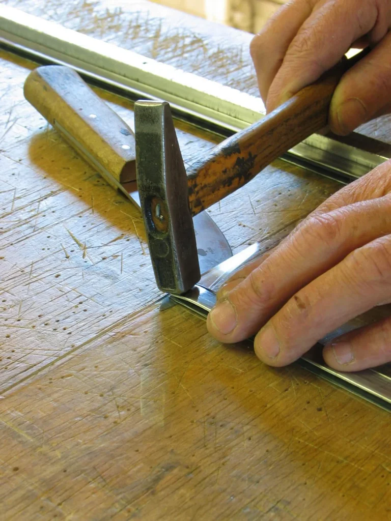 Glas-in-loodpaneel in bewerking op de werkbank