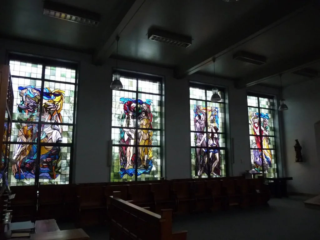 Vier hoge figuratieve kerkramen in een kerkinterieur