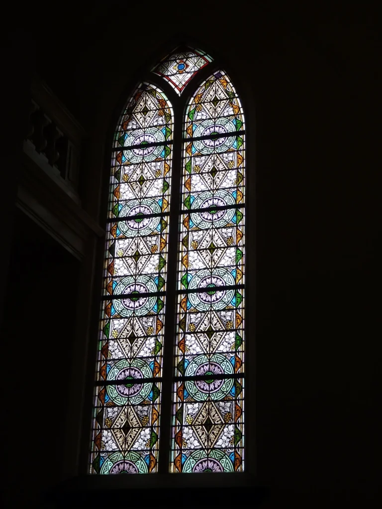 Gerestaureerd gotisch kerkraam met glas-in-lood, ornamenteel bloem- en rozetpatroon